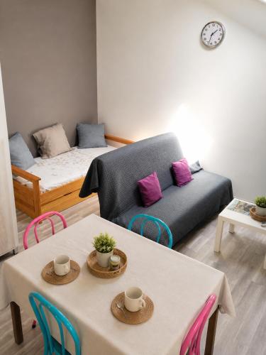 a living room with two tables and a couch at L'oiseau bleu in Salin-de-Giraud
