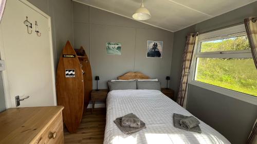 a bedroom with a bed and a window at Chalet 3 Wipeout in Hayle