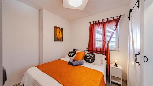 a bedroom with a bed with an orange blanket at Villa Anna by Villas Guide in Vela Luka