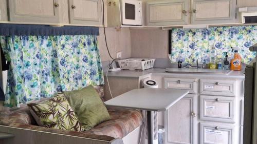 a kitchen with a couch and a table in a caravan at Caravan Rustic Sunflower in Mount Crosby