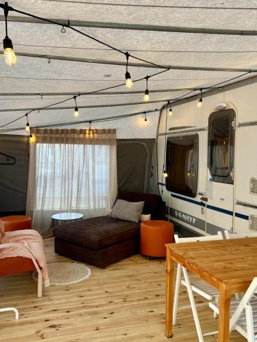 a living room with a couch and a bed in a trailer at Przyczepa kempingowa PannaMontata in Jastarnia