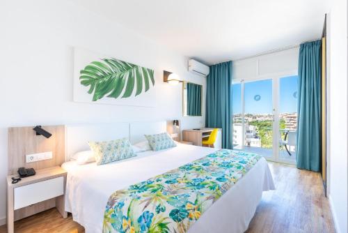 a hotel room with a bed and a large window at San Fermín by Dorobe in Benalmádena