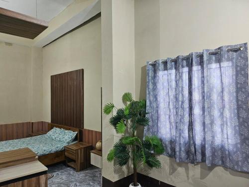 a bedroom with a bed and a blue curtain at The Glory Apartment room 1 in Imphal
