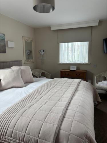 a bedroom with a large bed and a window at Canterbury Guest House in Sidmouth