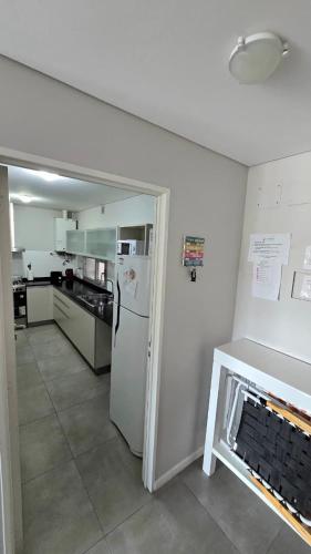 a kitchen with a white refrigerator and a stove at Pardelas playa y ballenas in Puerto Madryn
