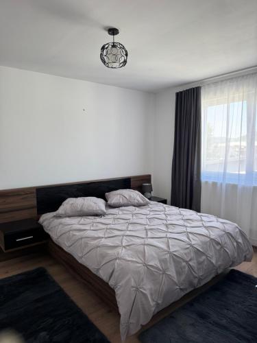 a bedroom with a large bed and a window at Bounty Home in Bistriţa