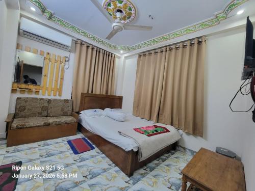 a bedroom with a bed and a chair in it at Hotel Zamzam Residential in Dhaka