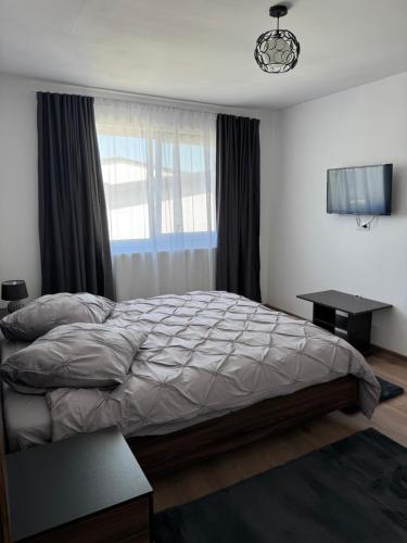 a bedroom with a bed and a desk and a window at Bounty Home in Bistriţa