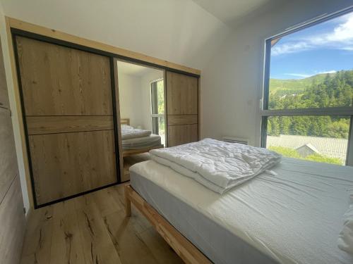 a bedroom with a bed and a large window at Duplex T4 residence les Etoiles du Sud in Le Lioran