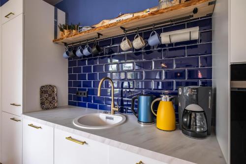 a kitchen with a sink and a blue tiled wall at Ferienhaus Inge in Büsum