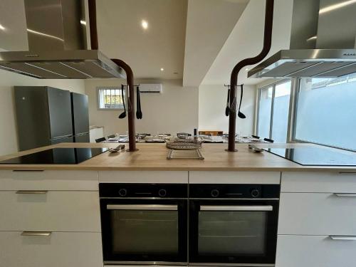a kitchen with a stove and a counter top at L'Apparth, maison partagée 7 chambres in Parthenay