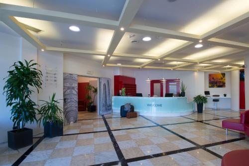 a lobby with a waiting area with potted plants at My One Hotel Bologna in Bologna