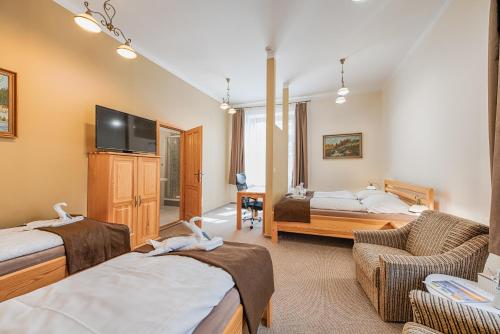 a hotel room with two beds and a tv at Penzion Vila Machů in Kopřivnice
