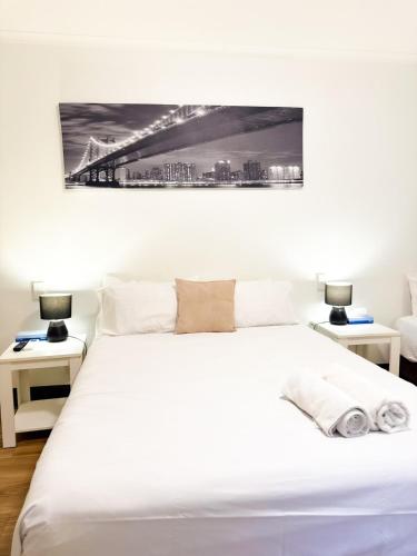 a bedroom with a white bed with two tables at studio Ex hotel room city 107 in Adelaide