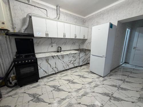a kitchen with a stove and a white refrigerator at Guest House in Gyumri in Gyumri