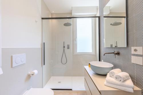 a white bathroom with a sink and a shower at Luxury Suites Collection - Ceccarini in Riccione