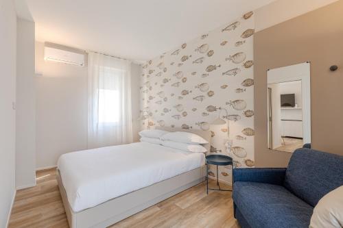 a bedroom with a white bed and a couch at Luxury Suites Collection - Ceccarini in Riccione