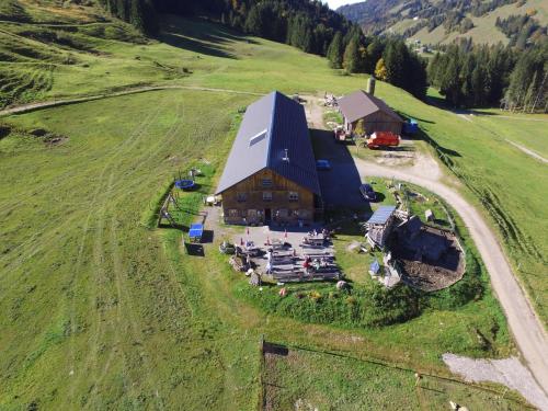 an aerial view of a large barn in a field at Jausenstation Neuschwand in Hittisau