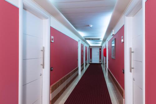 a corridor in a hospital with red walls and a red hallway at My One Hotel Bologna in Bologna