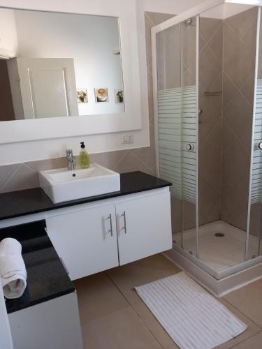 a white bathroom with a sink and a shower at Vilas Praia de Chaves Deluxe house sol y mar in Rabil