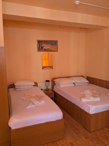 two beds sitting next to each other in a room at Hotel Tiver in Câmpia Turzii
