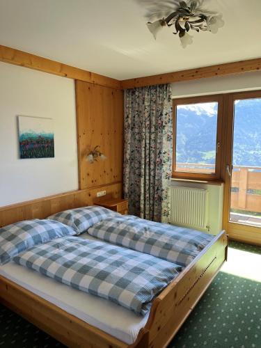 a bedroom with a bed and a large window at Meilerhof in Reith bei Seefeld