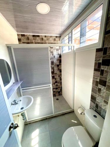 a bathroom with a shower and a toilet and a sink at Rincon Samario in Santa Marta