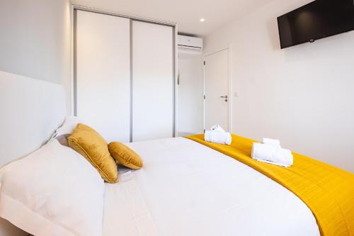 a bedroom with a white bed with yellow pillows at #081 1BR Vale Mangude Pool & Location in Albufeira