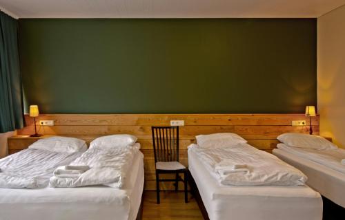 two beds in a room with a green wall at Hotel Post in Breiðdalsvík