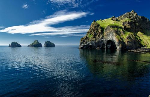 a group of large rocks in the water at Pier Apartments in Vestmannaeyjar