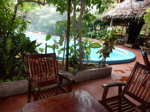 a patio with two chairs and a swimming pool at La Casa Fitzcarraldo in Iquitos