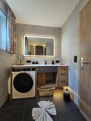a bathroom with a sink and a washing machine at Ferienhaus Antoinette in Biberwier