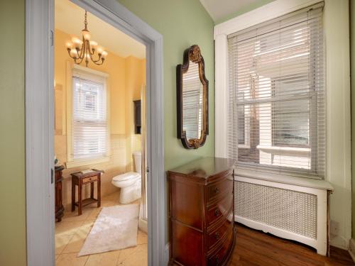 a bathroom with a toilet and a mirror at La Reserve On Pine in Philadelphia
