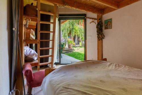 a bedroom with a bed and a door to a yard at Logement Bourbon - coeur Ardèche in Lamastre