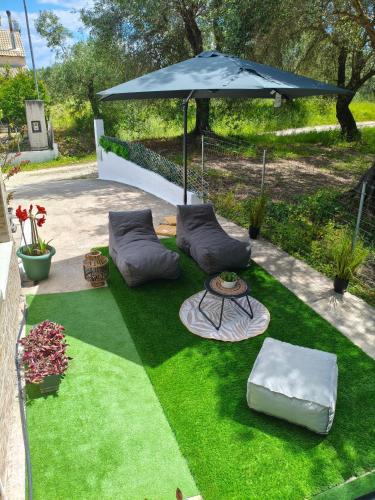 a lawn with a table and an umbrella at Marathi Apartment in Marathias