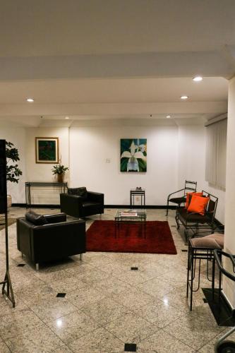 a large living room with couches and a table at Hotel Vila Rica Flat in Resende
