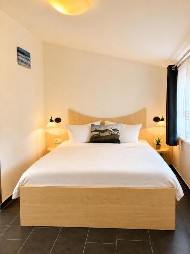 a bedroom with a large bed with white sheets at Hotel Pension Vineta Rügen in Baabe