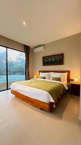a bedroom with a large bed and a large window at 3BR Nava villa Ubud in Ubud