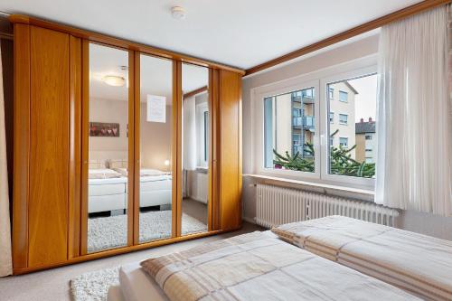 a bedroom with a bed and a large window at Ferienwohnung Mand in Weinheim