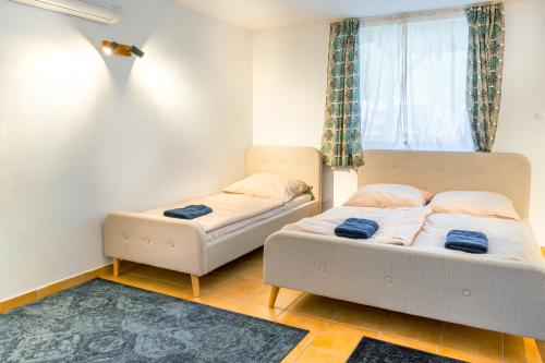 a bedroom with two beds and a window at Villány Outback in Kisjakabfalva
