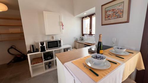 a kitchen with a table with a bottle of wine on it at Casa Chula Estudio in Jimena de la Frontera