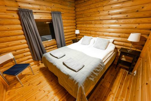 a bedroom with a bed in a log cabin at Brimnes Bungalows in Ólafsfjörður