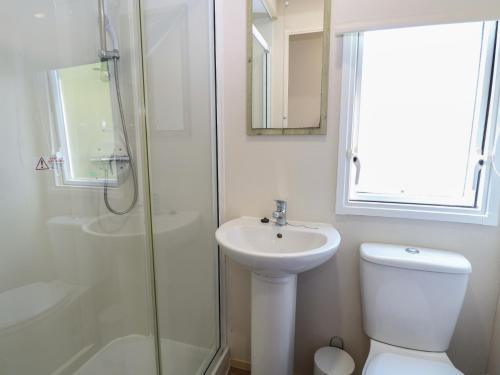 a bathroom with a toilet and a sink and a shower at Caravan 325 in Lowestoft