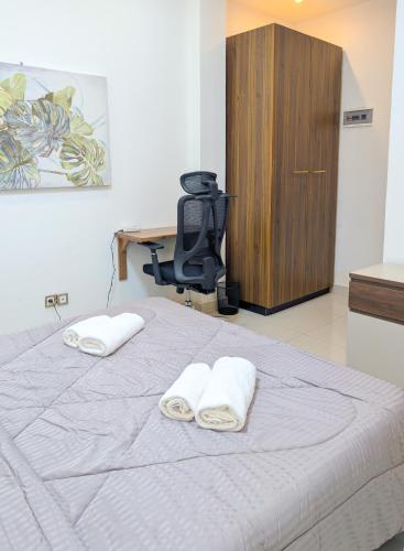 ein Schlafzimmer mit einem Bett, auf dem zwei Handtücher liegen in der Unterkunft Meublés tout confort à Makepe - Immeuble KOLA - Groupe Électrogène in Douala