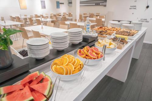 a buffet line with plates and bowls of fruit at Reykjavik Lights Hotel by Keahotels in Reykjavík