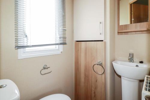 a bathroom with a toilet and a sink at The Oakley in Par