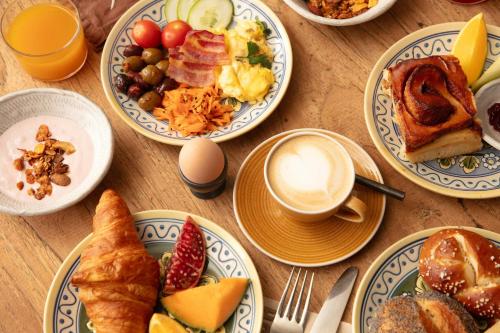 a table with plates of breakfast foods and a cup of coffee at Lulu Guldsmeden in Berlin