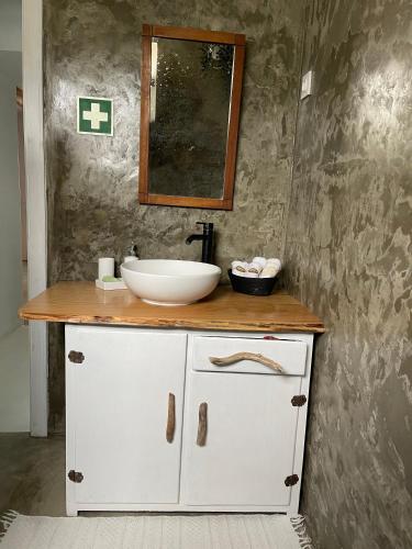 a bathroom with a white sink and a mirror at Casa Baía da Lagoa in Lagoa