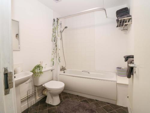 a bathroom with a toilet and a tub and a sink at Apartment 2 in Aberdeen