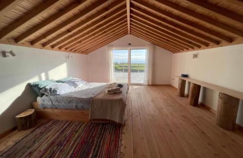 a bedroom with a bed and a large window at Casa Baía da Lagoa in Lagoa